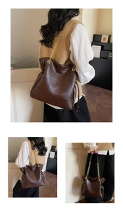 Detail view of dark brown leather bucket bag with geometric stitching and gold chain