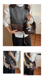 Brown lychee leather bucket bag set with silver hardware and a plush bear charm detail