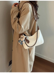 Détail du sac bandoulière blanc avec chaîne décorative et breloque ourson mignon