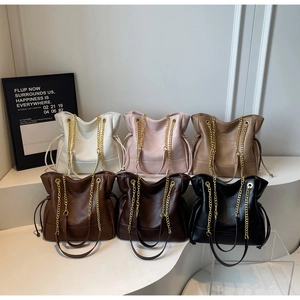 Detail view of colorful bucket bags showing leather texture and gold chain straps