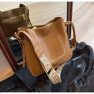 Gros plan du sac fourre-tout marron avec coutures décoratives et bandoulière tissée