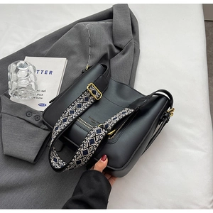 Détail du sac cabas noir avec bandoulière géométrique et fermoirs dorés vintage