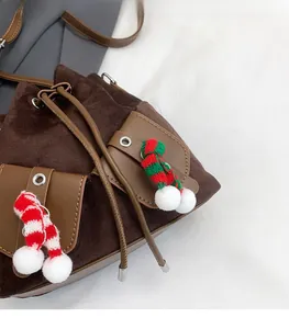 Détail du sac seau en daim marron avec écharpe de Noël festive et cordon de serrage
