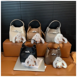 Detailed view of bucket bags in five colors with cute plush bunny charms and silver buckles
