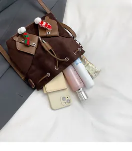 Détail de l'intérieur spacieux du sac seau en daim marron avec téléphone et accessoires