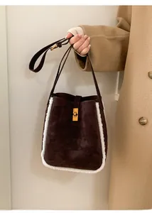 Detail der Winter-Wildleder-Beuteltasche mit weißem Pelzbesatz und goldener Schließe
