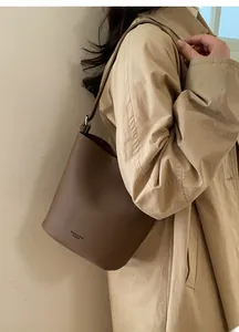 Detail of dark brown lychee leather bucket bag with silver buckle and branding