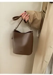 Close-up of large capacity bucket bag in brown pebble leather with logo detail