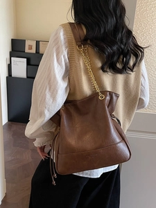 Deep brown vintage leather bucket bag with geometric stitching and chain strap
