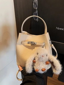 Chic beige lychee leather bucket bag with silver buckle and cute rabbit charm
