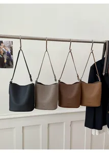 Close-up of four lychee textured leather bucket bags in black, taupe, coffee and khaki