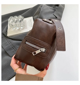 Detail of dark brown lychee leather texture and silver hardware on shoulder bag