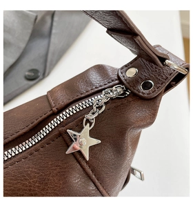 Detail of dark brown lychee texture leather bag with silver star zipper and rivets