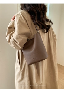 Detail of dark brown lychee leather bucket bag with adjustable strap for commuting