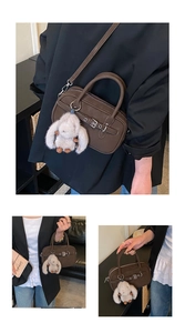 Detail view of dark brown faux leather bag with metal buckle and plush rabbit pendant