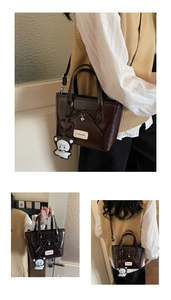Detail of dark brown bucket bag with shiny leather, bow accent, and cute bear charm