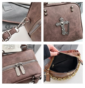 Detail view of vintage tan leather pillow bag showing hardware, cross charm and dual zippers