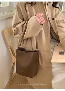 Detailed view of the dark brown lychee texture leather bucket bag with shoulder strap
