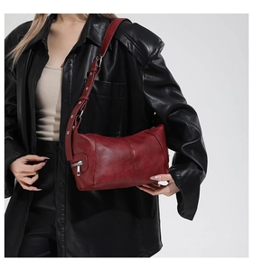 Detailed macro view of deep red textured leather texture and silver hardware accents