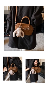 Detail of vintage brown crossbody bag with metal buckle and plush bunny charm