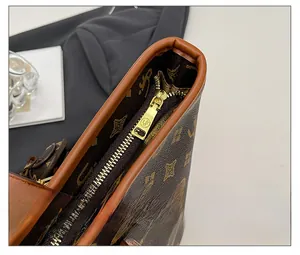 Detail shot of the golden metal zipper and vintage monogram texture on the tote bag