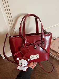 Red retro bucket handbag with cute heart charm and bow details shown in a lifestyle setting