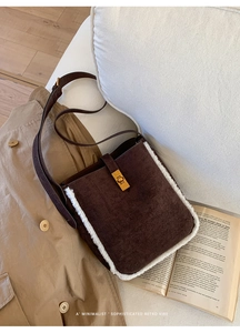 Detail der braunen Wildleder-Beuteltasche mit weißem Lammfellbesatz und Goldschnalle