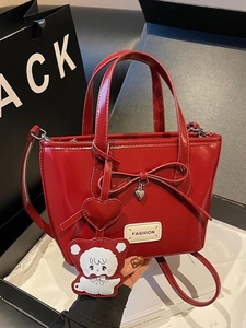 Red glossy patent leather bucket bag with bow decoration and stylish top handle