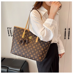 Detail of vintage tote bag featuring brown monogram pattern and kangaroo metal emblem