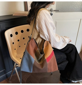 Detail of a large capacity patchwork canvas shoulder bag with geometric color blocks