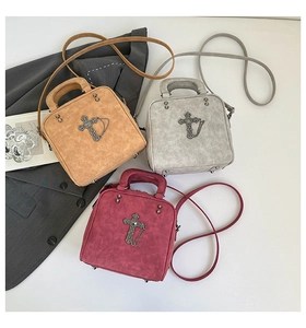 Macro detail of vintage pillow handbag with metallic cross decor in three color variants