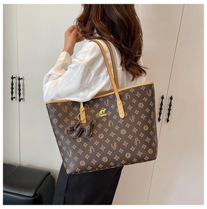 Detail of vintage monogram tote bag featuring leather dog charm and gold kangaroo logo