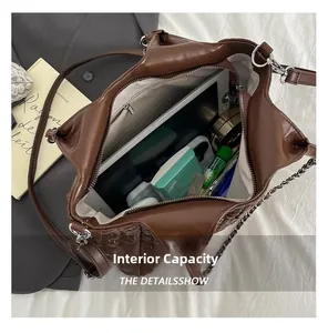Internal capacity of brown pleated tote bag showing tablet, phone and makeup essentials
