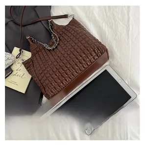 Detailed close-up of brown woven texture tote bag with silver chain and leather strap