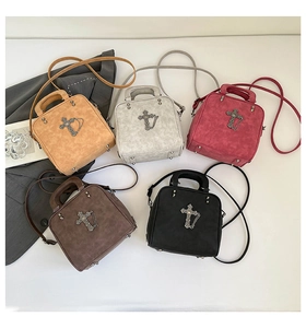 Flat lay of vintage pillow bags in five colors with Gothic cross and chain details
