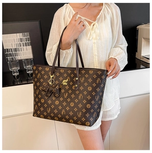 Detail of vintage bucket tote bag with floral monogram print and golden kangaroo logo
