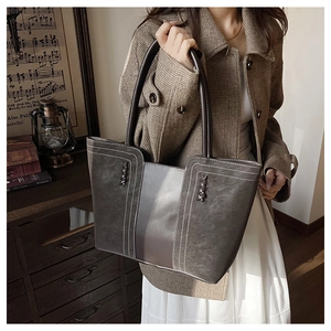 Detail view of large dark brown retro tote bag with white contrast stitching accents