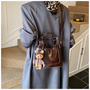 Dark brown faux leather bucket bag with white contrast stitching and cute bear charm
