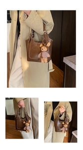 Detail of dark coffee bucket bag with leather texture and cute teddy bear charm