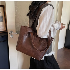 Large dark brown vintage leather tote bag shown on model for daily commuting style
