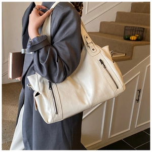 Detailed side view of ivory large tote bag on shoulder showing soft faux leather texture
