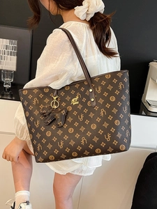 Vintage brown monogram tote bag with gold kangaroo logo and decorative black dog charm