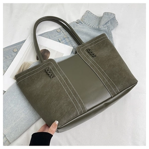 Detailed close-up of vintage tote bag featuring mixed leather texture and contrast stitching