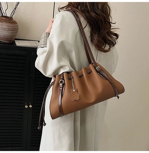 Detail of caramel tote bag with pleated drawstring closure and bear-shaped pendant tag