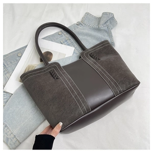 Detail of vintage tote bag featuring contrast stitching and mixed texture materials