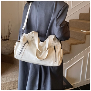 Detail of cream white large capacity shoulder bag with soft leather and zip pockets