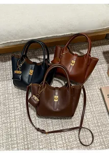 Detail view of leather handbags with golden twist locks and mini decorative pouches