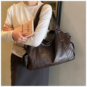 Macro detail of dark brown soft faux leather handbag with textured pleats and zip pockets