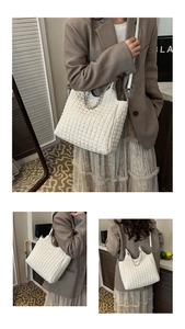 Detail of white quilted bubble tote bag with silver chain strap and metal triangle plaque