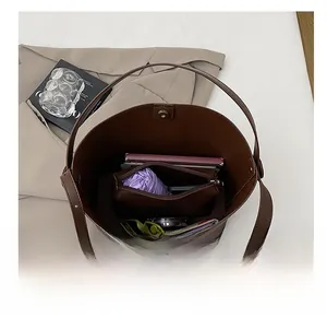 Interno spazioso della borsa tote marrone scuro che mostra la capacità per l'uso quotidiano